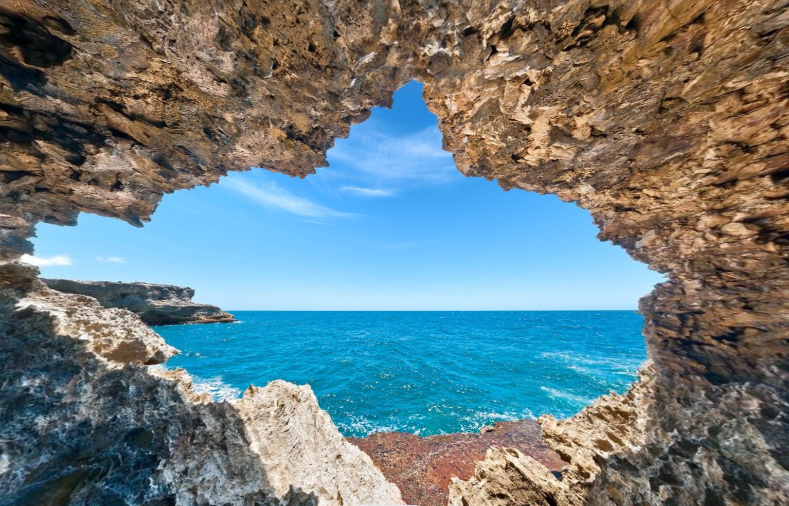 Rugged sea cave opening to blue Atlantic water